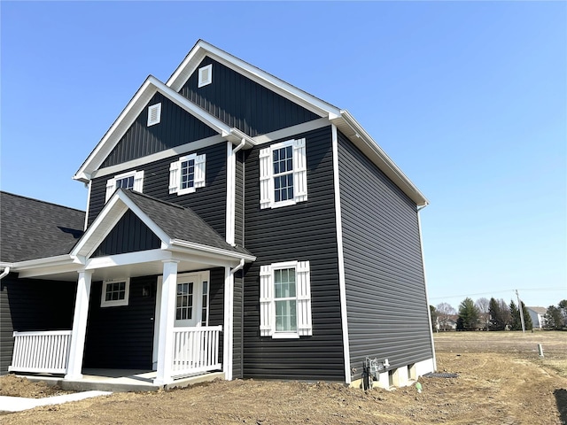 view of front of property featuring covered porch, board and batten siding, and a shingled roof