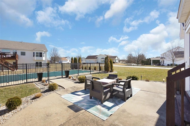 view of patio featuring a community pool, fence, and a residential view