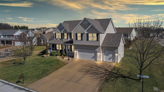 view of front of house with a shingled roof, concrete driveway, a front yard, a garage, and a residential view