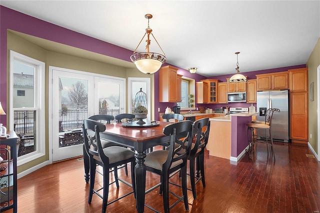 dining area featuring dark wood-style floors and baseboards