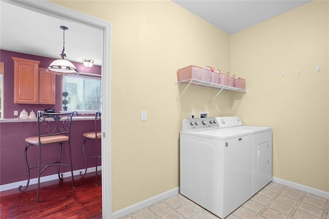 laundry room featuring laundry area, light floors, independent washer and dryer, and baseboards