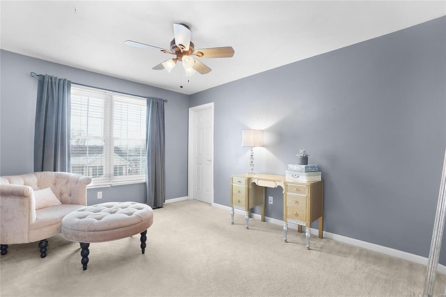 carpeted office space featuring a ceiling fan and baseboards