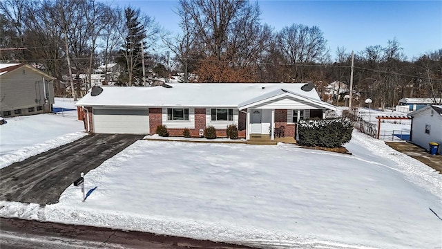 ranch-style house featuring brick siding, driveway, and an attached garage