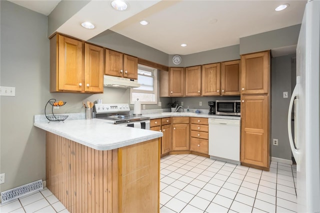 kitchen featuring white appliances, visible vents, a peninsula, light countertops, and under cabinet range hood