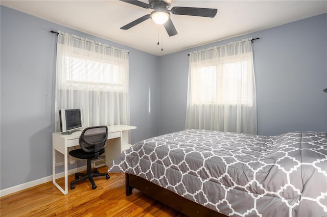 bedroom with wood finished floors, a ceiling fan, and baseboards