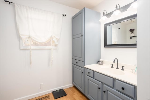 bathroom with vanity, baseboards, and wood finished floors