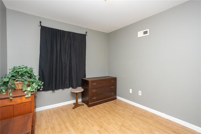 interior space with light wood-style floors, baseboards, and visible vents