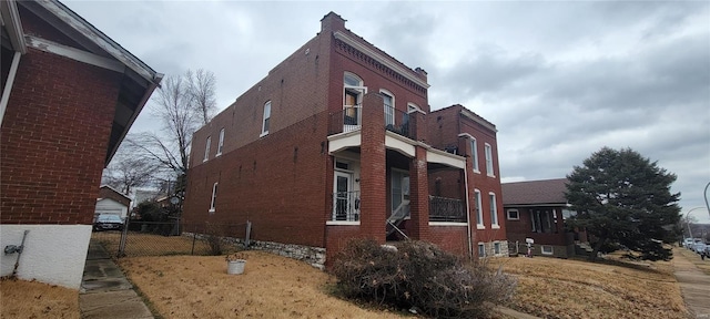 view of property exterior with fence and brick siding