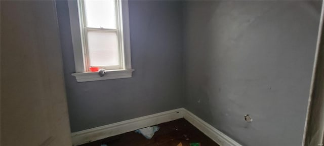 unfurnished room with baseboards