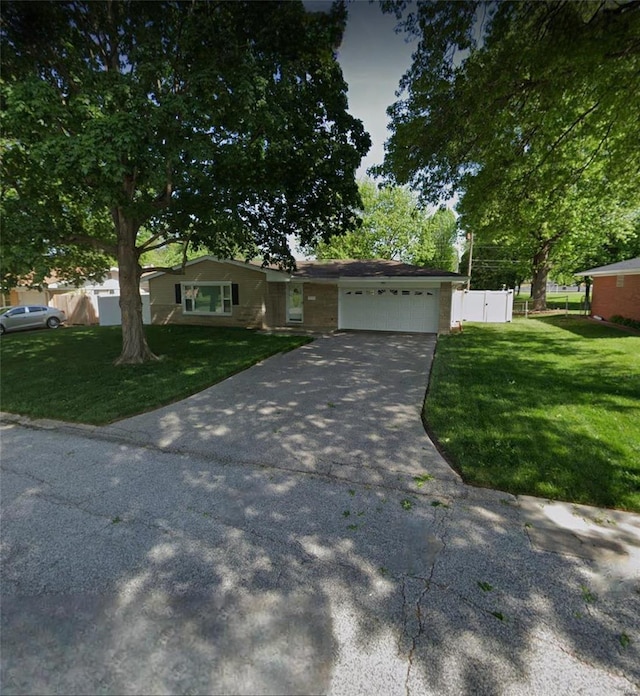 ranch-style home featuring a garage and a front lawn