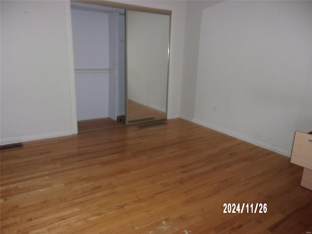 unfurnished bedroom featuring a closet and light wood-type flooring