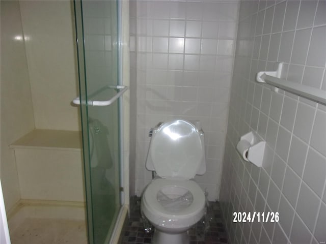 bathroom with toilet, tile walls, and walk in shower