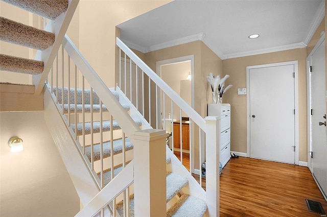 foyer with wood-type flooring and crown molding