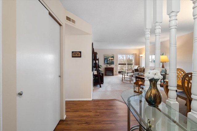 hallway with hardwood / wood-style flooring and decorative columns