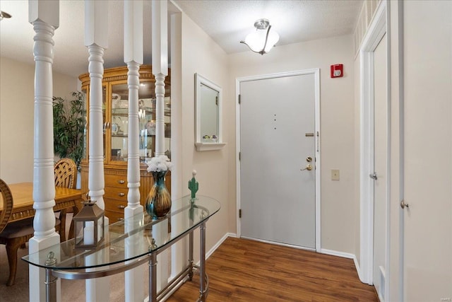 entrance foyer featuring wood-type flooring and ornate columns