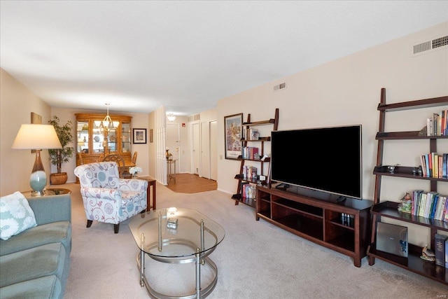 living room featuring light colored carpet and a notable chandelier