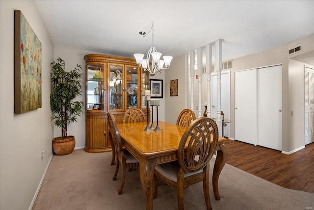 dining area with dark colored carpet and a chandelier