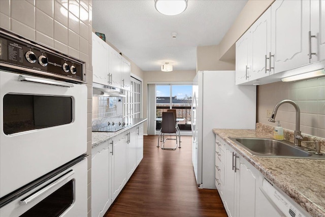 kitchen featuring tasteful backsplash, white cabinetry, sink, dark hardwood / wood-style flooring, and white appliances