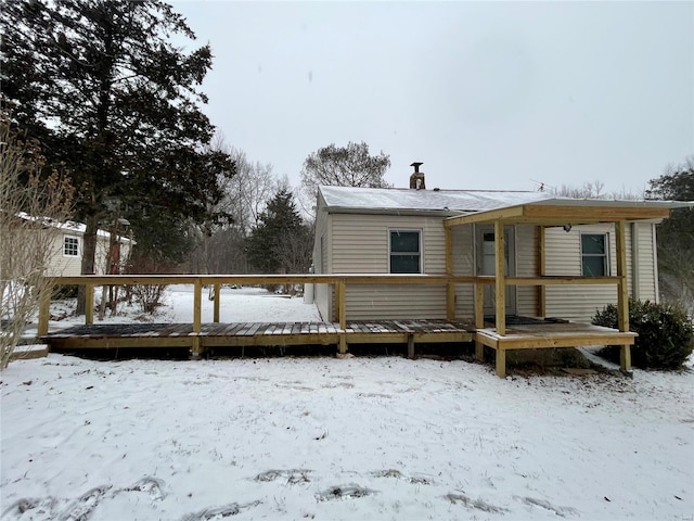 snow covered property with a wooden deck