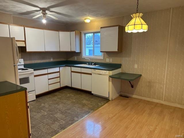 kitchen with white cabinetry, sink, pendant lighting, and white appliances