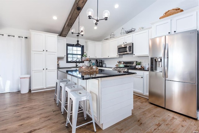 kitchen with white cabinetry, pendant lighting, a center island, and appliances with stainless steel finishes