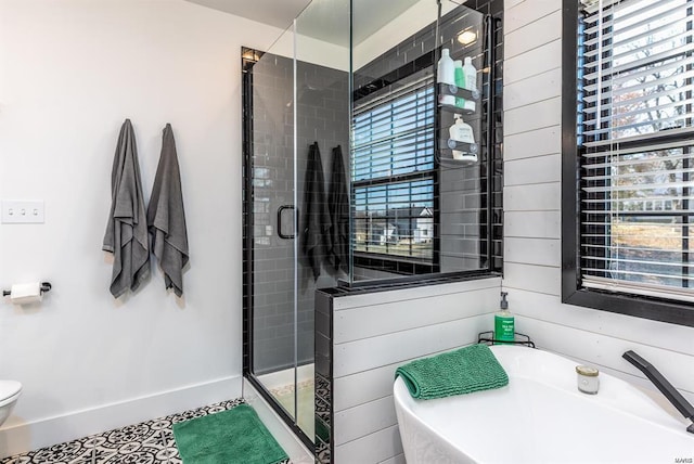 bathroom with a shower with shower door, a healthy amount of sunlight, and wood walls