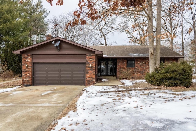 single story home featuring concrete driveway, brick siding, a chimney, and an attached garage