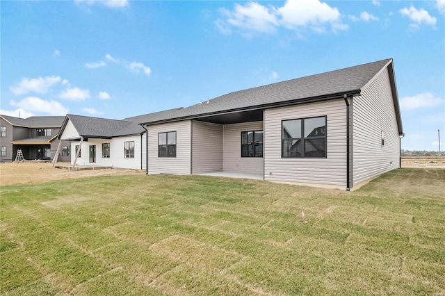 rear view of property with a yard and a patio