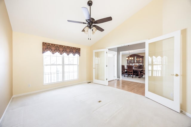 carpeted empty room with french doors, high vaulted ceiling, and ceiling fan