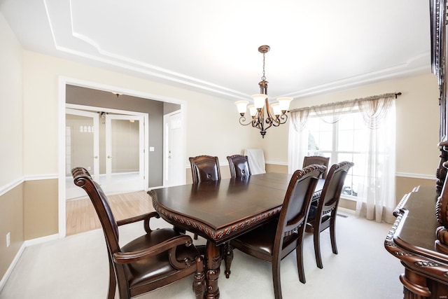 dining area featuring a tray ceiling and a chandelier