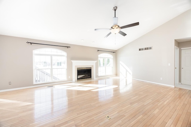 unfurnished living room featuring ceiling fan, light wood-type flooring, and high vaulted ceiling