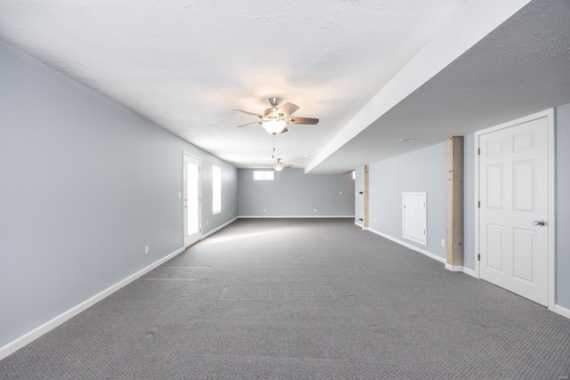 unfurnished room with dark carpet, ceiling fan, and a textured ceiling