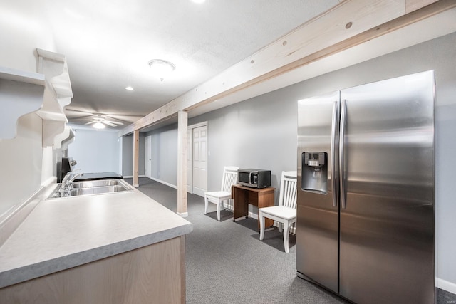 kitchen with appliances with stainless steel finishes, sink, and dark colored carpet