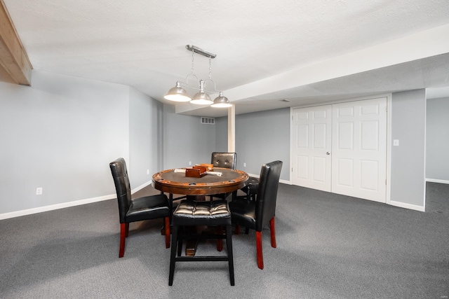 carpeted dining room with a textured ceiling