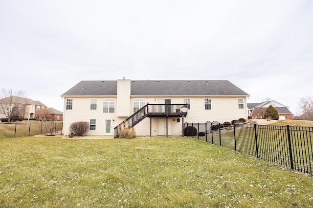 back of property featuring a wooden deck and a lawn