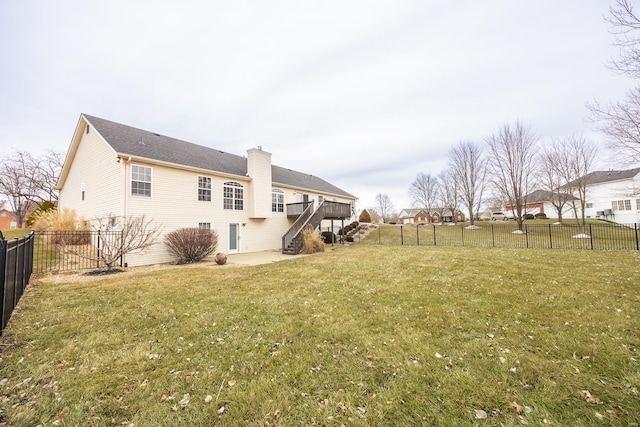 back of property featuring a yard and a wooden deck