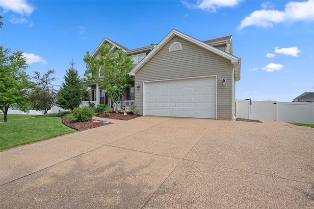 view of front facade featuring concrete driveway, an attached garage, a front yard, a gate, and fence