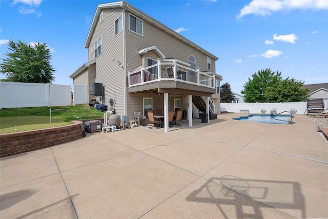 rear view of house featuring a deck, a fenced backyard, stairway, a fenced in pool, and a patio area