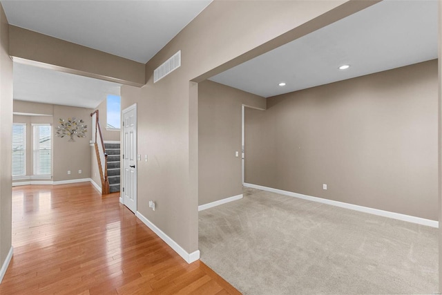 interior space featuring baseboards, stairs, visible vents, and light wood-style flooring