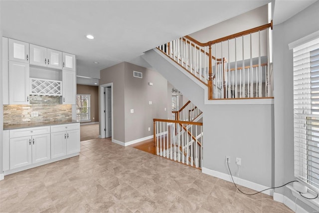 kitchen featuring tasteful backsplash, baseboards, visible vents, white cabinets, and recessed lighting