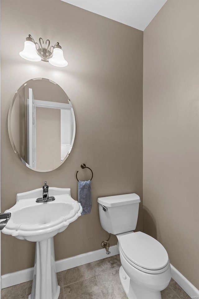 half bath featuring toilet, baseboards, and tile patterned floors