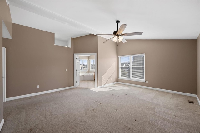 empty room featuring lofted ceiling, ceiling fan, baseboards, and light colored carpet