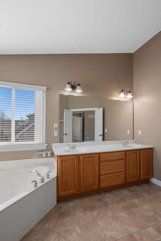 full bath with a garden tub, double vanity, tile patterned flooring, and a sink