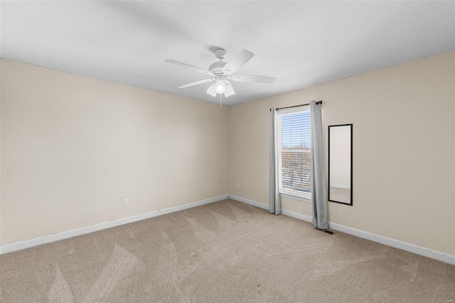 unfurnished room with baseboards, a ceiling fan, and light colored carpet