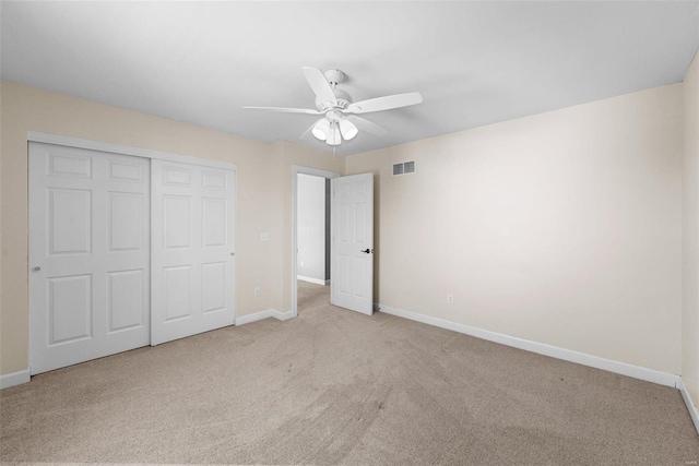 unfurnished bedroom with a closet, carpet, visible vents, and baseboards