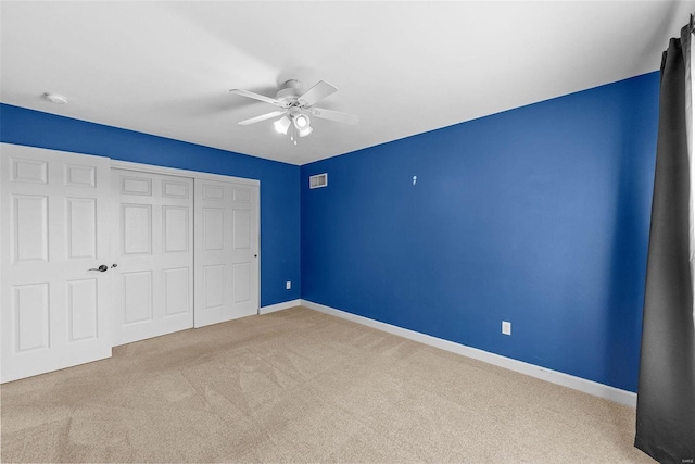 unfurnished bedroom featuring carpet floors, a closet, visible vents, and baseboards