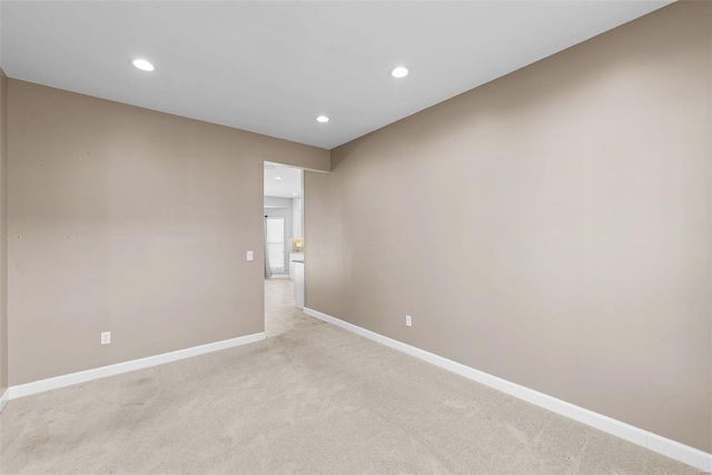 unfurnished room featuring recessed lighting, light carpet, and baseboards