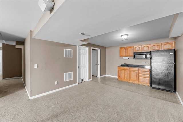 kitchen with visible vents, light carpet, and black appliances