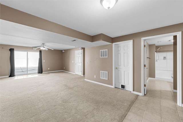 empty room with baseboards, visible vents, ceiling fan, and light colored carpet