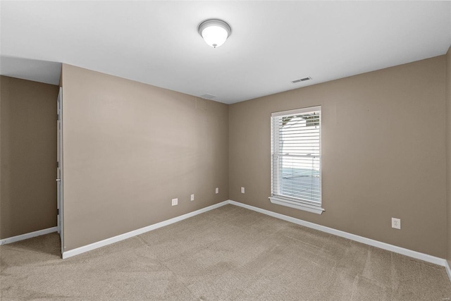 unfurnished room with carpet flooring, visible vents, and baseboards